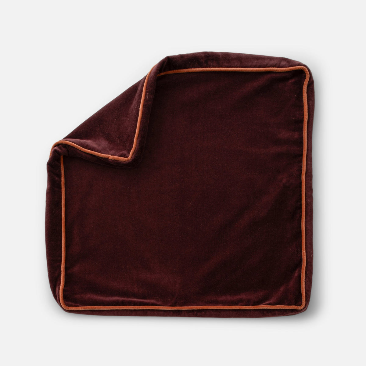 Front view of Velvet Piped Pillow Cover showcasing deep burgundy velvet with contrasting tan piping against a white background