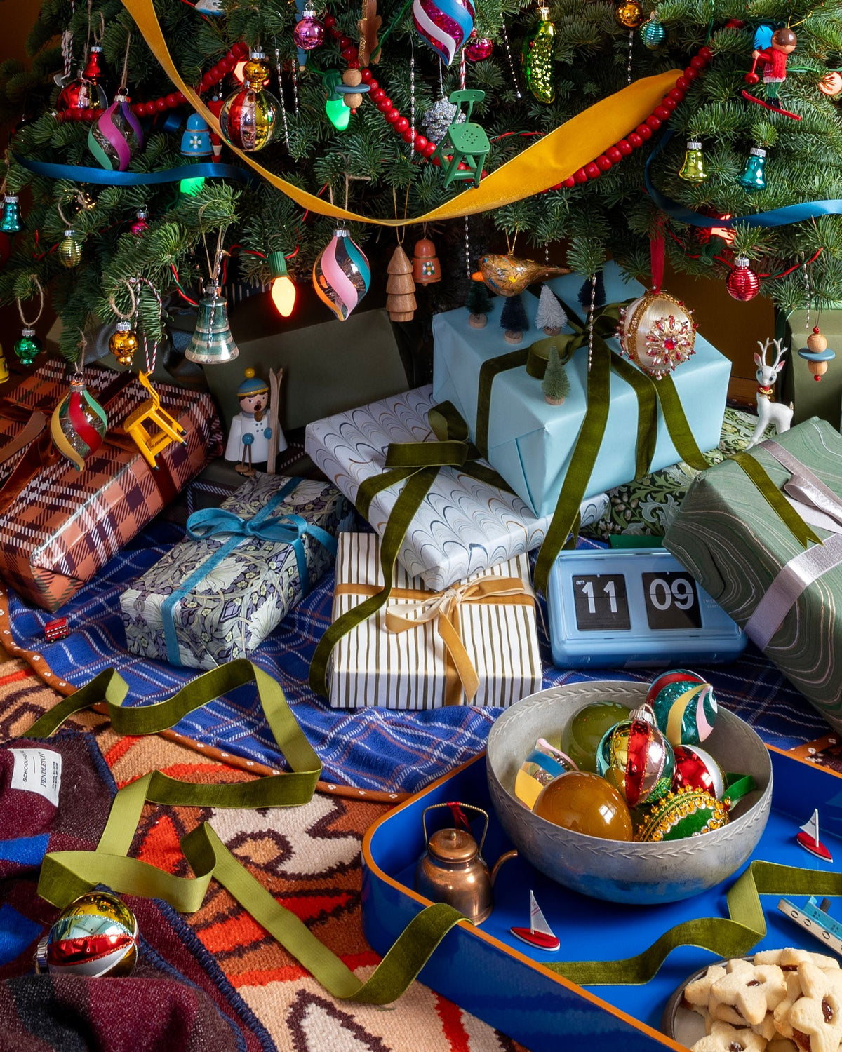 Holiday I Spy display filled with gifts, ornaments, miniature trees, sailboats, skiers, and a utility stool