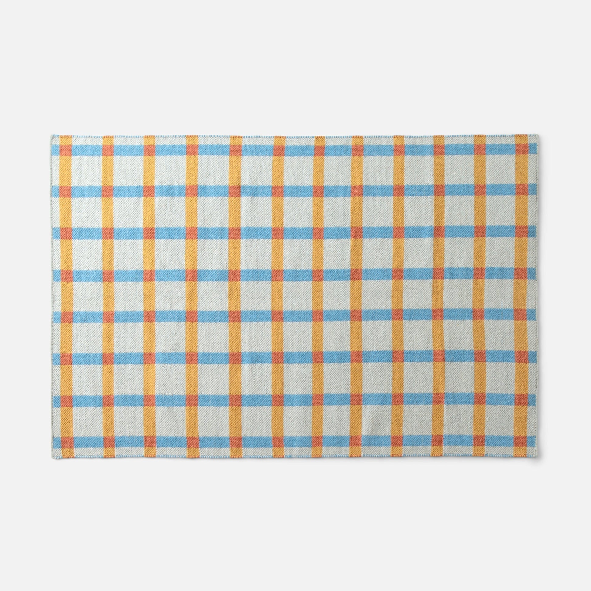 Top-edge view of Plaid Wool Reversible Rug showcasing blue, yellow, and orange plaid handwoven wool on white background