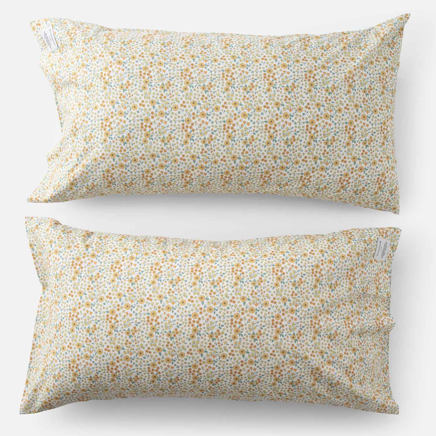 Top-down of two Wallowa Floral percale pillowcases (set of 2) showing small chamomile wildflower print on white background
