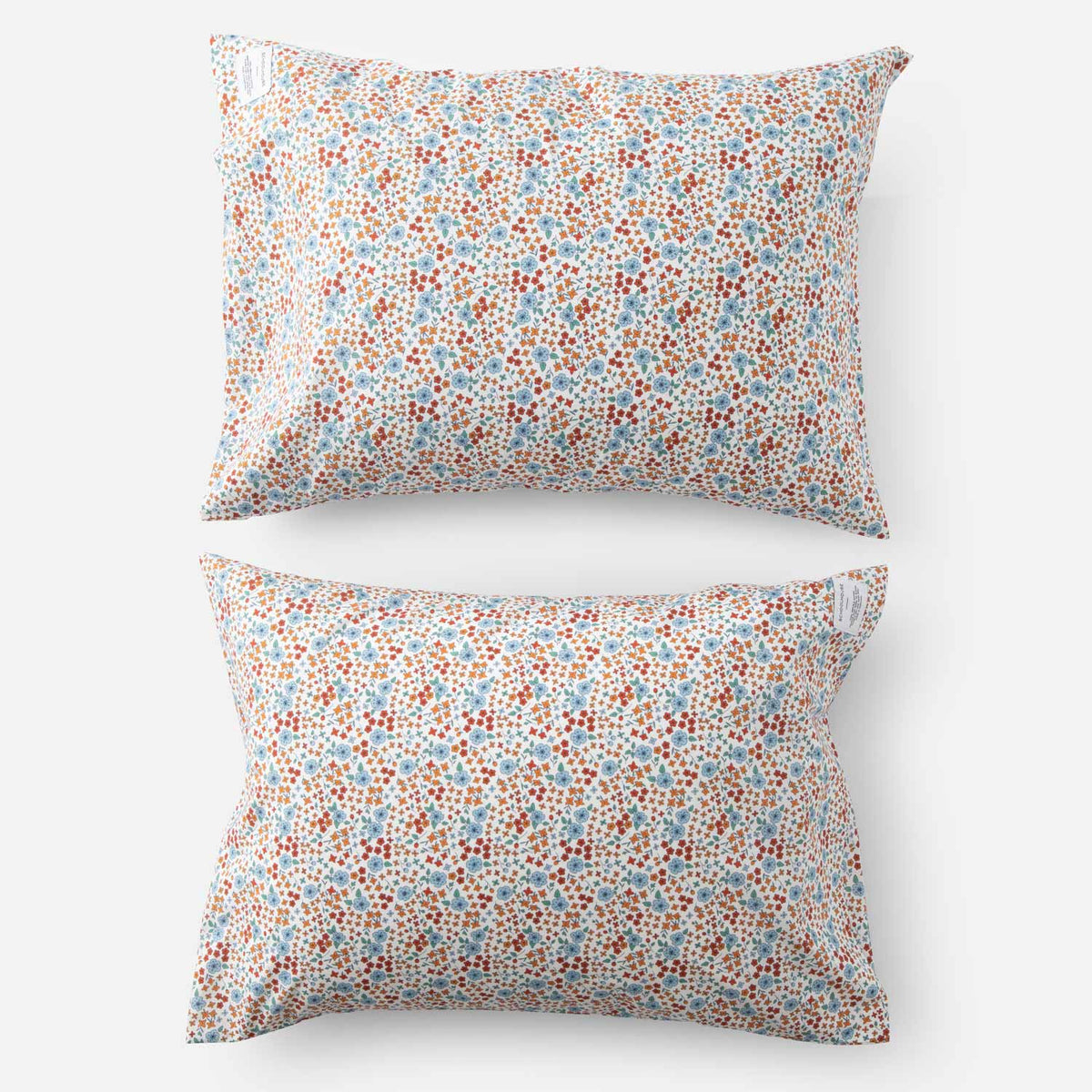 Top-down view of two Wallowa floral percale pillowcases showcasing small multicolor floral print on white studio background