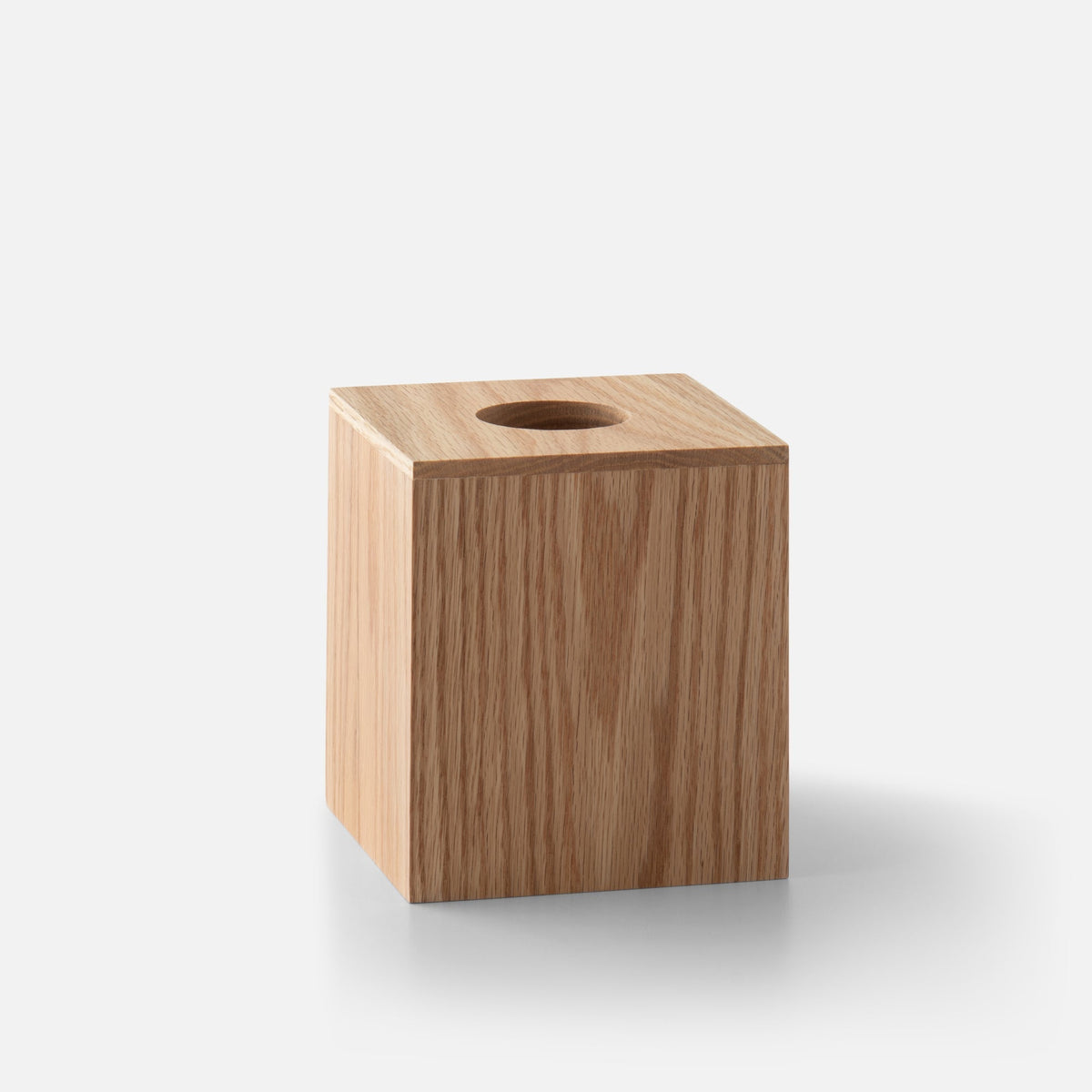Three-quarter view of Oak Tissue Box Cube showcasing natural oak wood and top tissue opening on a white background