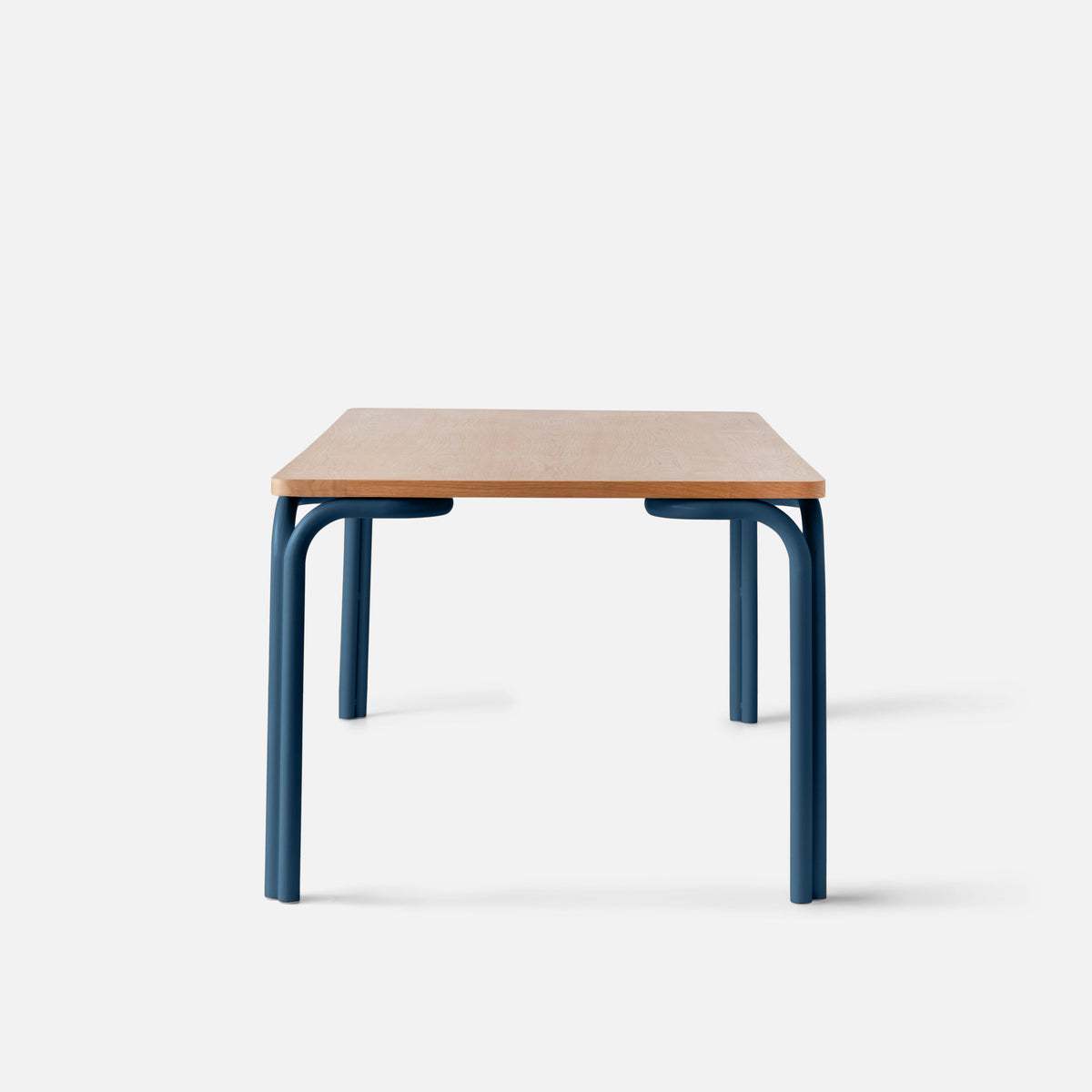 Front view of Forma Dining Table showcasing a wooden top and blue powder-coated steel legs against a white background
