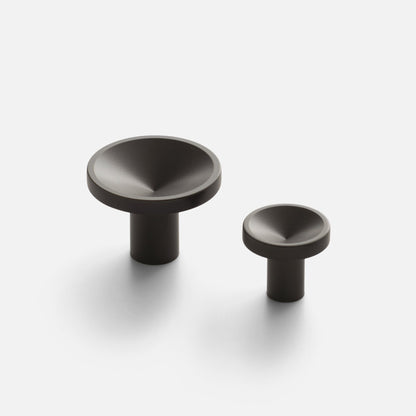 Close-up of two Rhone Knob sizes showcasing textured recessed faces and cylindrical stems on a white background