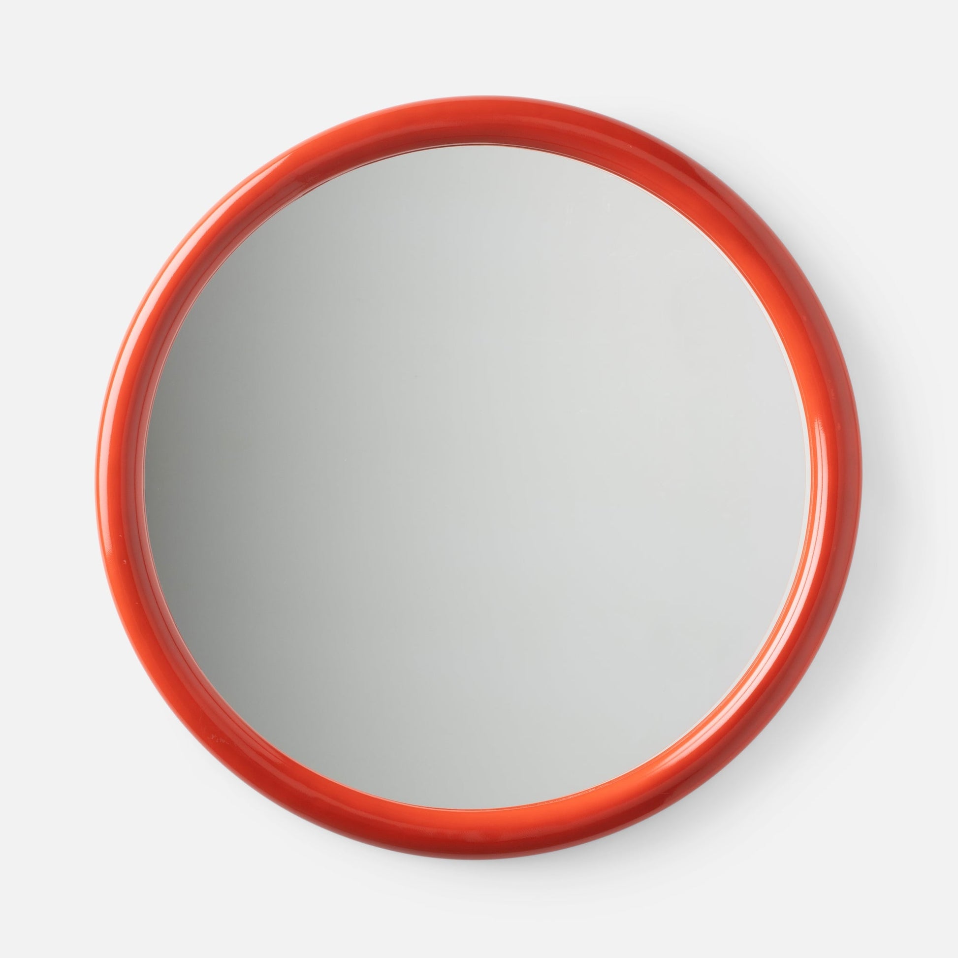 Close-up top view of Forma Mirror showcasing glossy orange-red rounded frame with white background