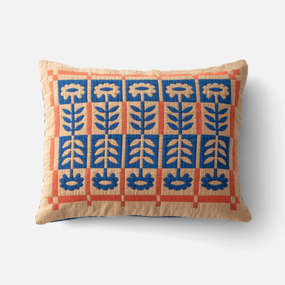 Top view of Stillwater Floral Sham showcasing mirrored blue floral applique and orange grid color blocking on beige background