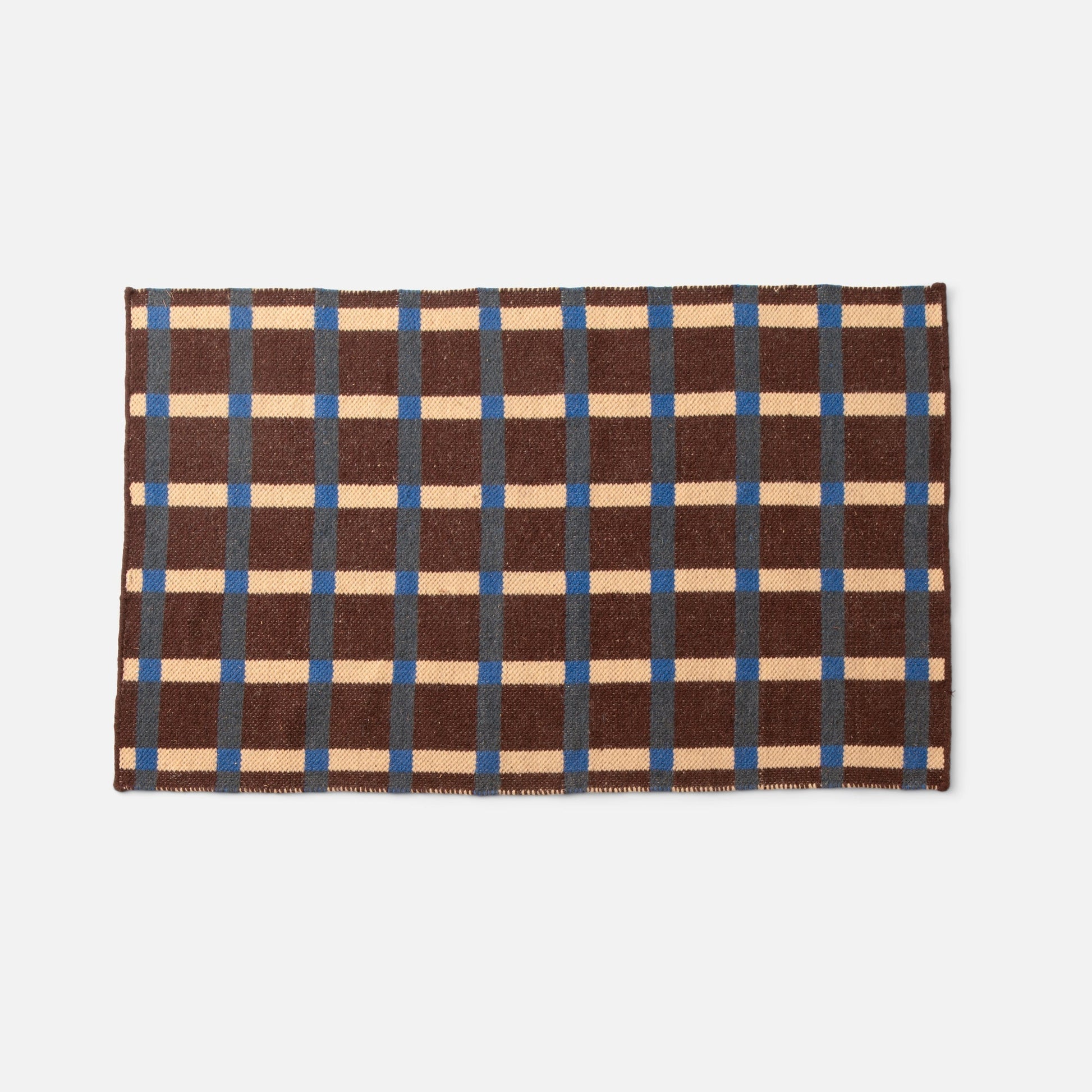 Top-down view of Plaid Wool Reversible Rug showcasing brown, cream and blue high-contrast plaid and woven texture on white background