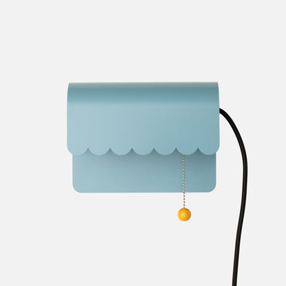 Front view of Dolores Plug-In Sconce showcasing scalloped edge, pull chain, and cord against a white background