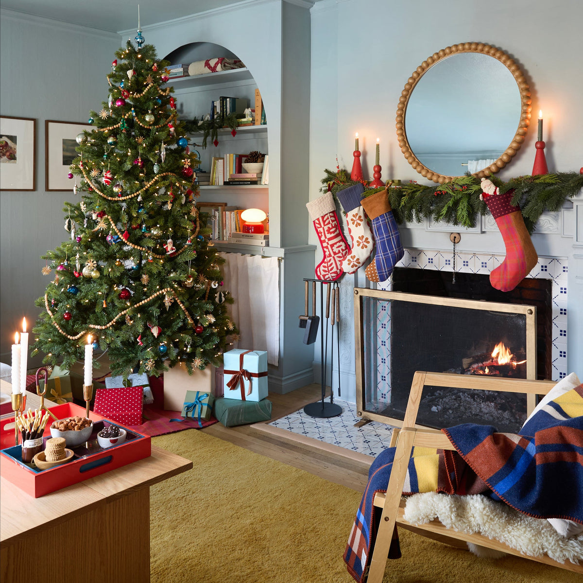 Stillwater Stocking hanging on a garland-draped fireplace mantel in a festive living room