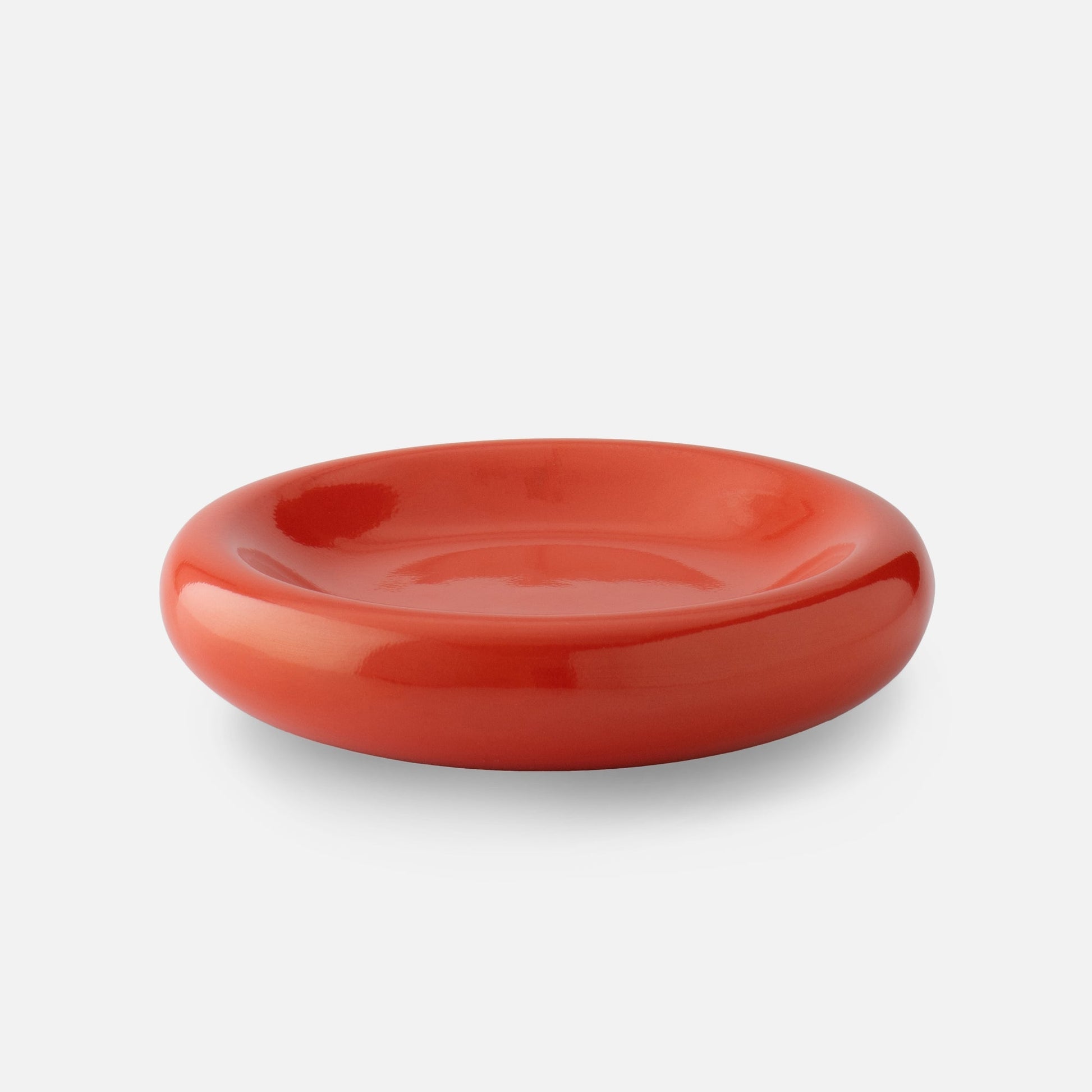 Close up front view of Yves cast metal catch all in raisin gloss showing rounded bowl shape and glossy finish on white background