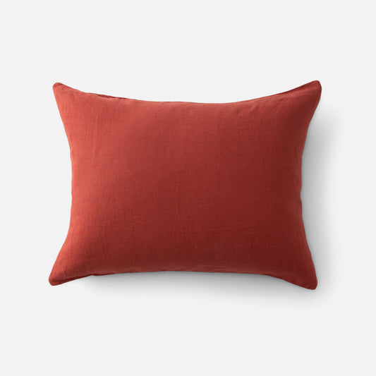Top view of linen pillow sham in paprika showcasing textured linen fabric and knife-edge seam on white background
