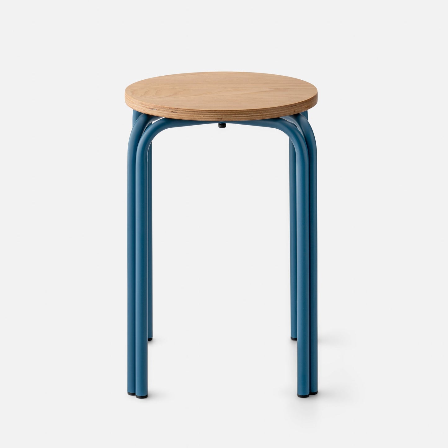 Front view of Forma Stool with round white oak top, exposed plywood edge, and indigo powder-coated steel legs on a white background