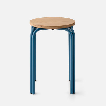 Front view of Forma Stool with round white oak top, exposed plywood edge, and indigo powder-coated steel legs on a white background