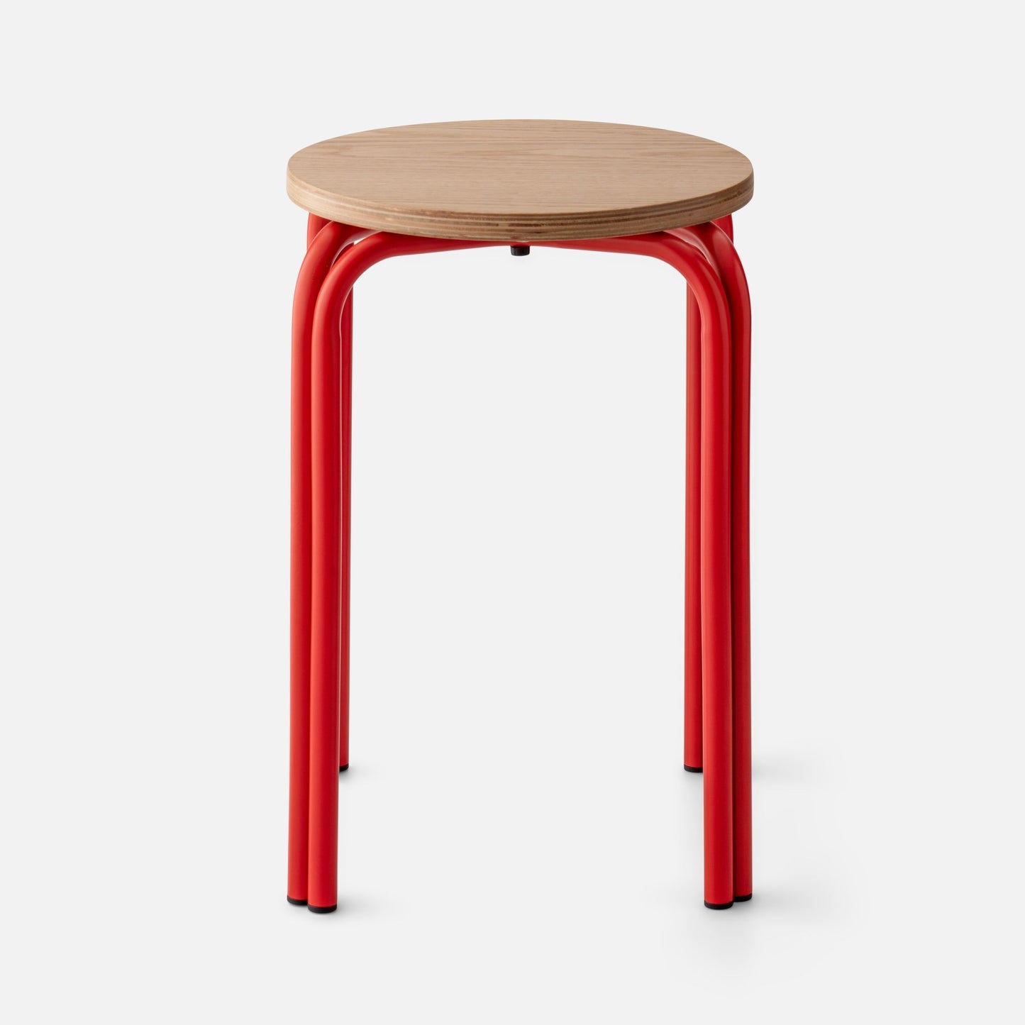 Close-up of Forma Stool showing white oak top with plywood edge and red powder-coated steel legs on white background