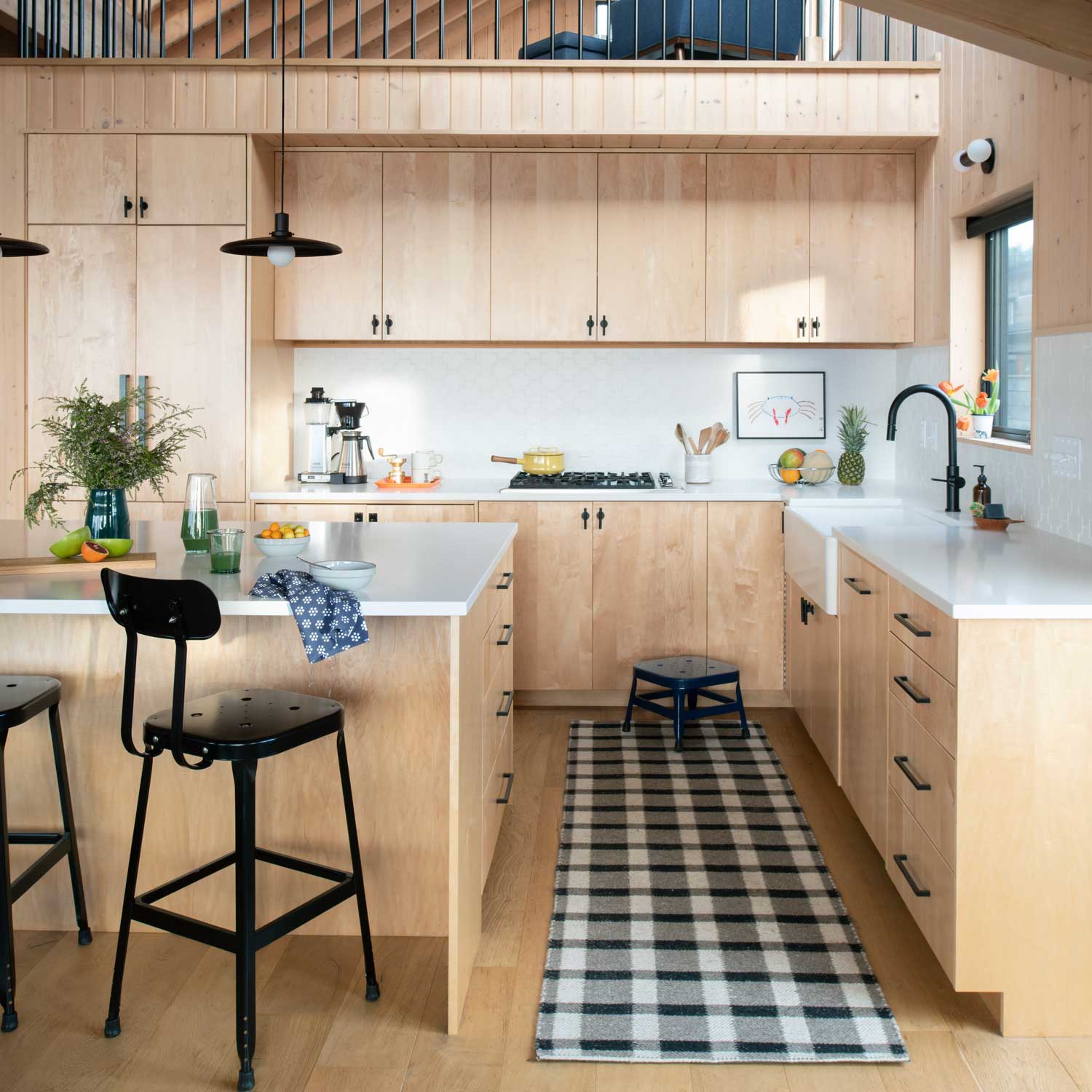 Kitchen interior with light maple cabinets and island showcasing black Galley Pull cabinet handles and pendant lights