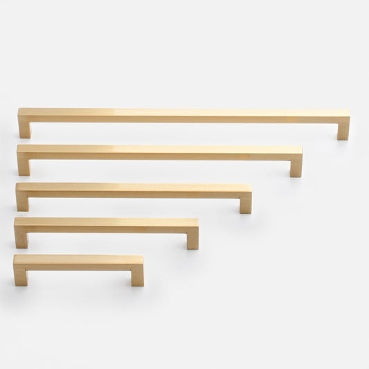 Angled view of Edgecliff pulls showcasing natural brass finish in five sizes on white background