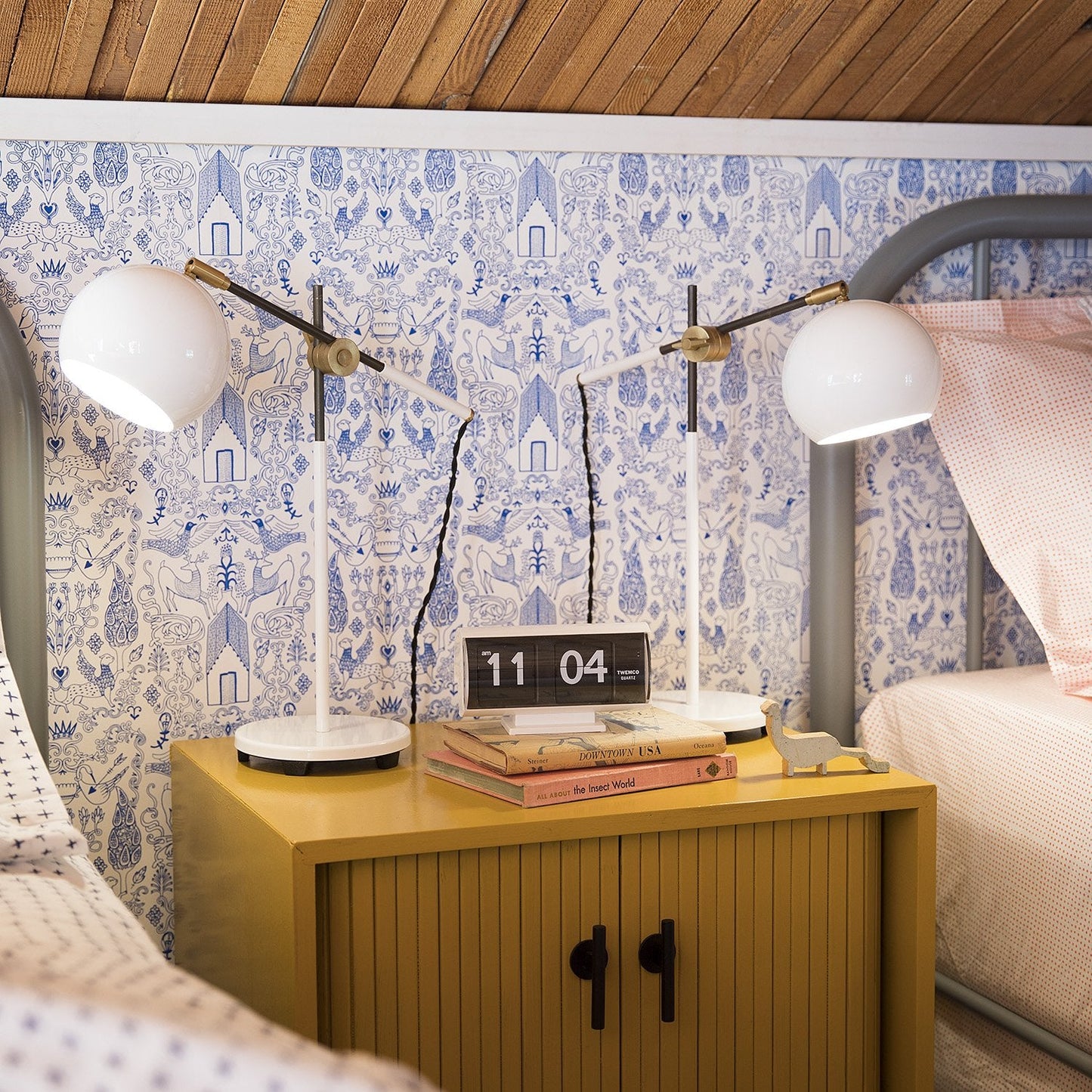 Front view of Galley Pull on yellow nightstand showing black straight pull with bedside lamps