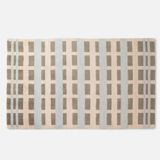 Top-down view of Network tufted wool rug showcasing a tufted geometric grid pattern in sky blue and taupe on a white background