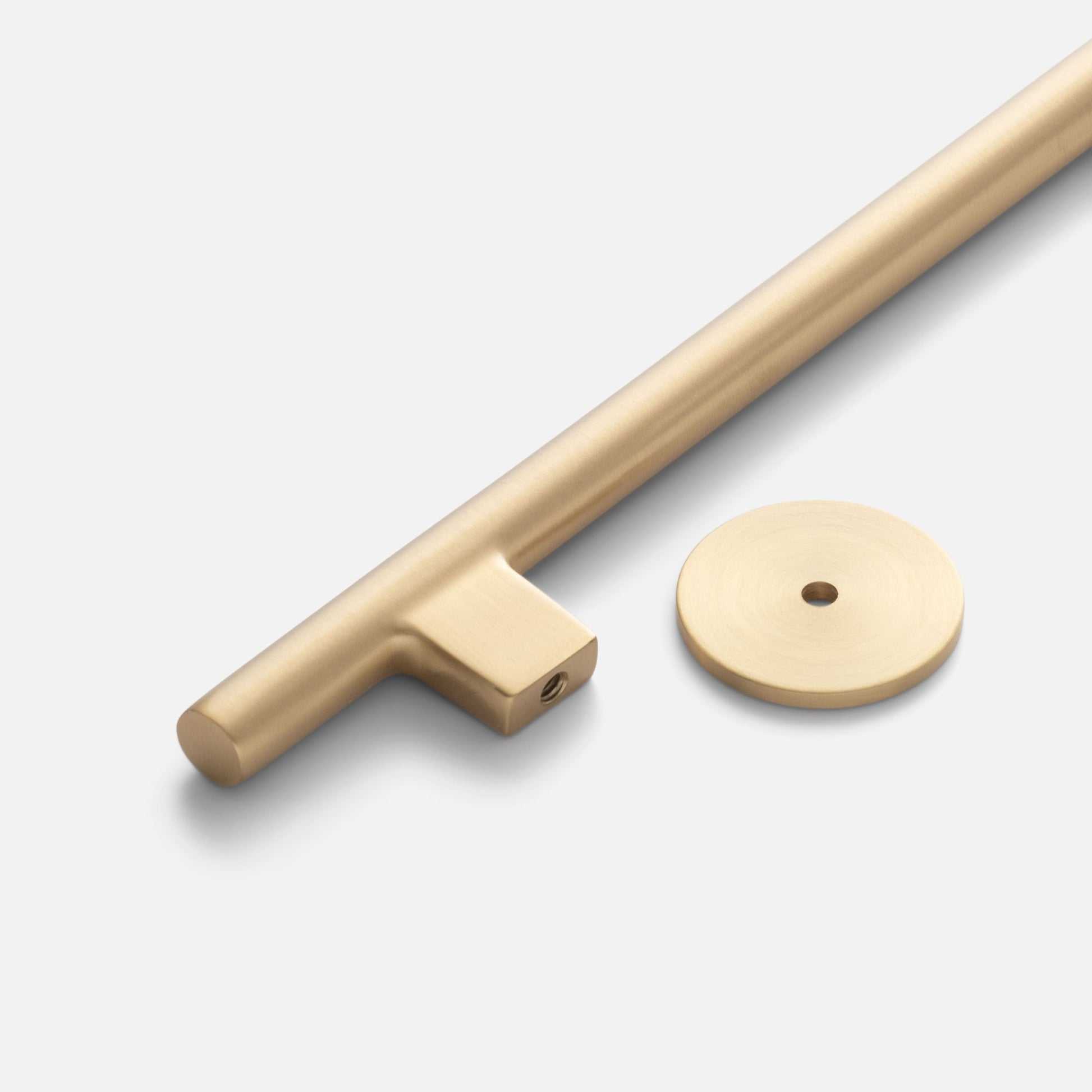 Angled close-up of Galley Pull showing natural brass finish, brushed texture, and round rosette on a light gray background
