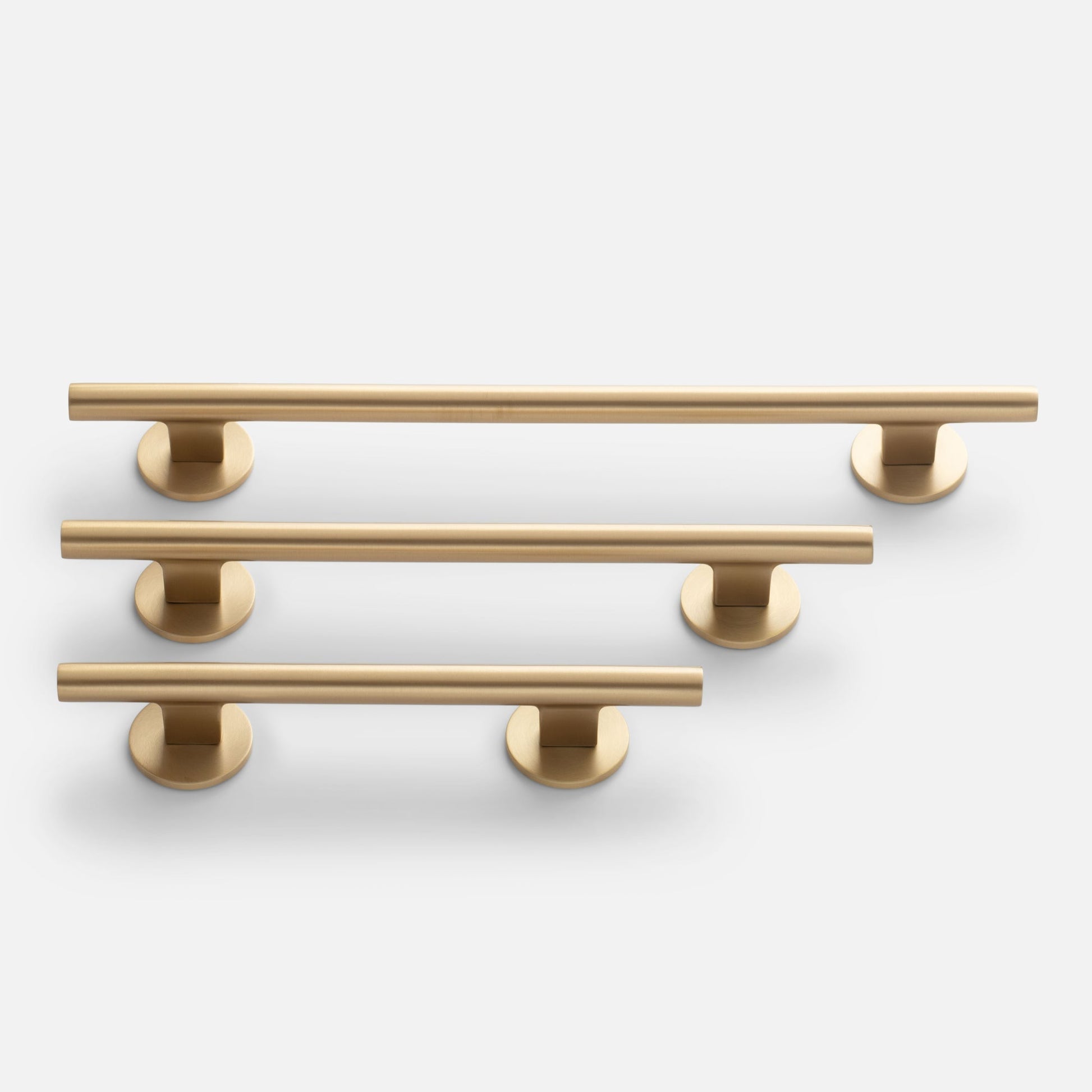 Close up front view of Galley Pull showing natural brass tubular bar and round mounts on white background