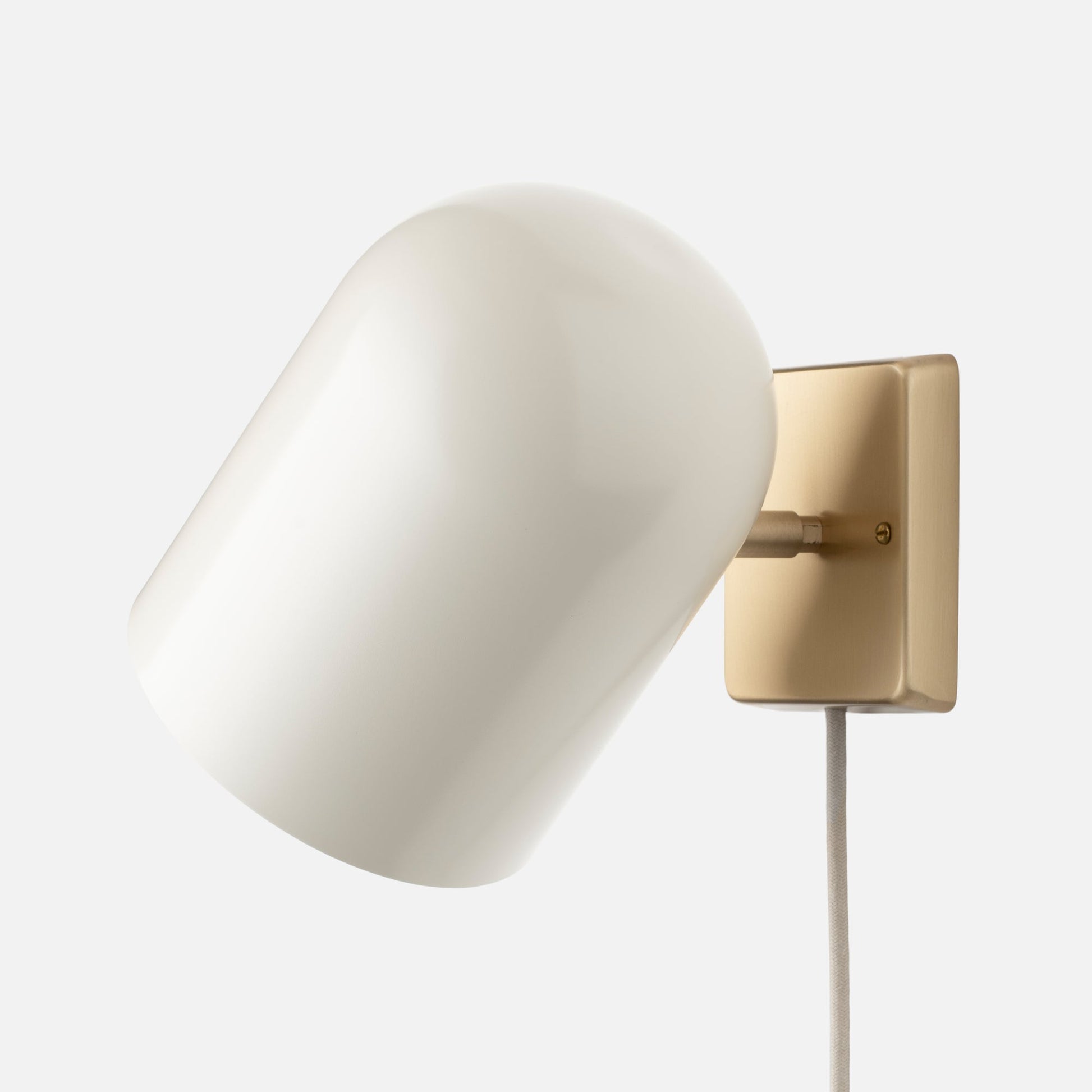Angled close-up of Allegheny 6-inch Plug-In Sconce showing opal glass shade and satin brass backplate on white background