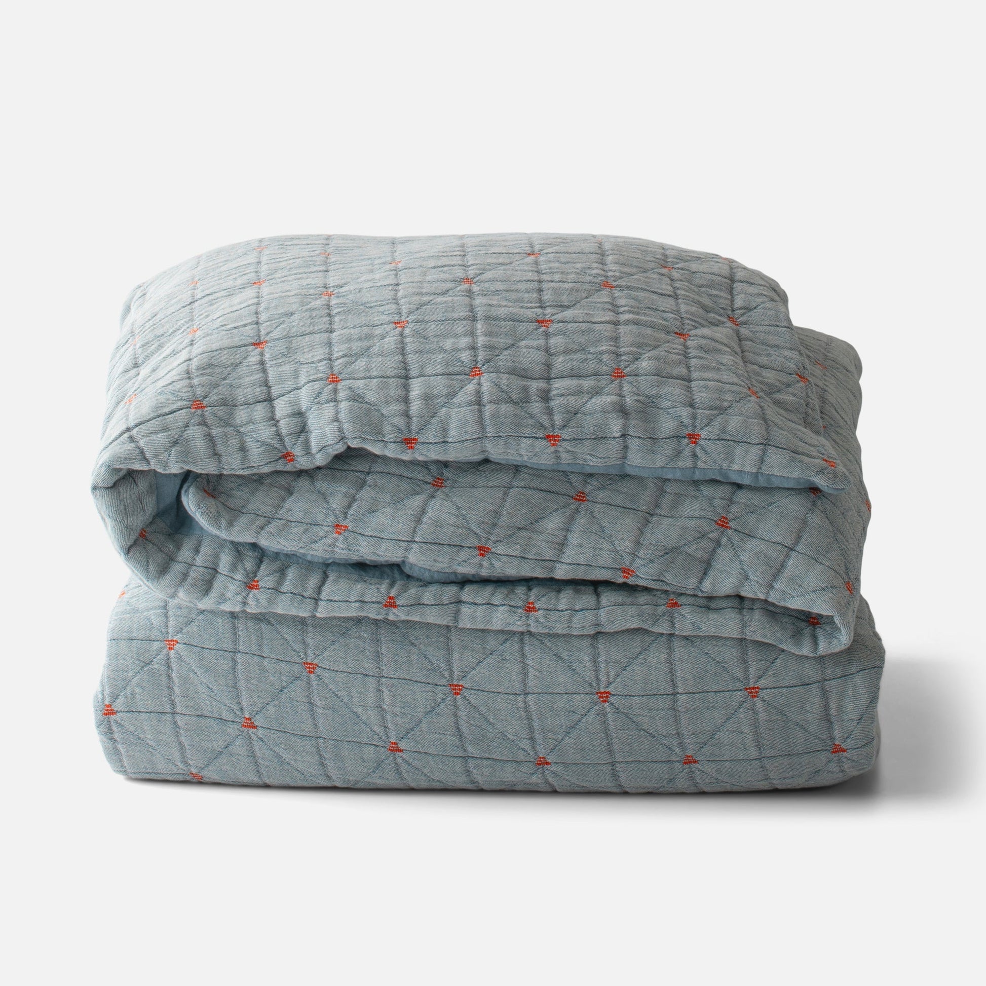 Folded Peak Stitch Duvet in olive with triangular quilting and red yarn tie stitches on matelasse fabric on white